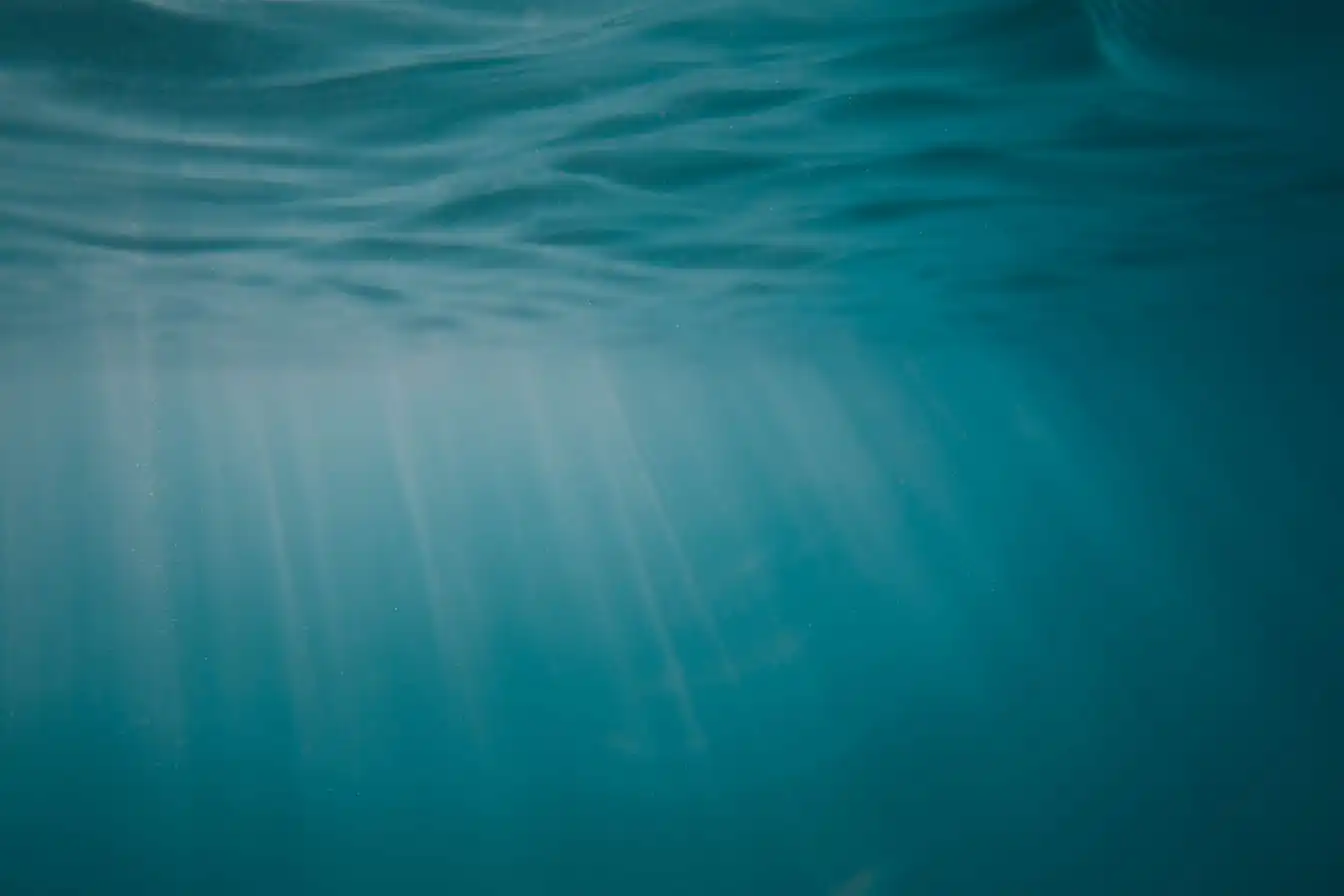 Sunlight reaching down through clear blue sea water.